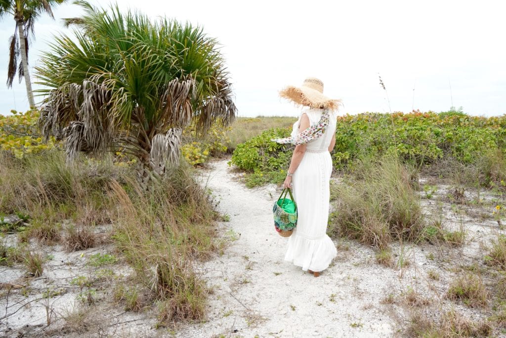 white maxi dress with ruffle details- large green straw tote bag-large straw hat-tropical sand dunes