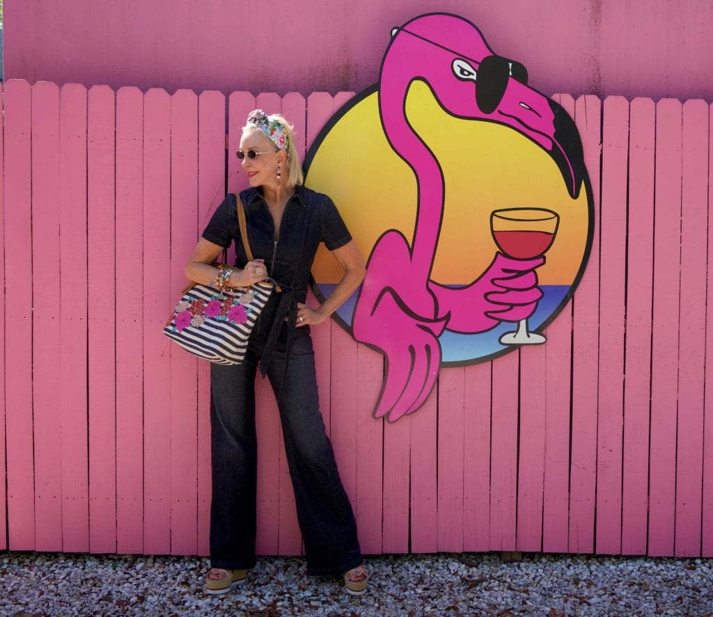 dark blue denim jumpsuit, stipe & floral tote bag, pink wall, Flamingo wall