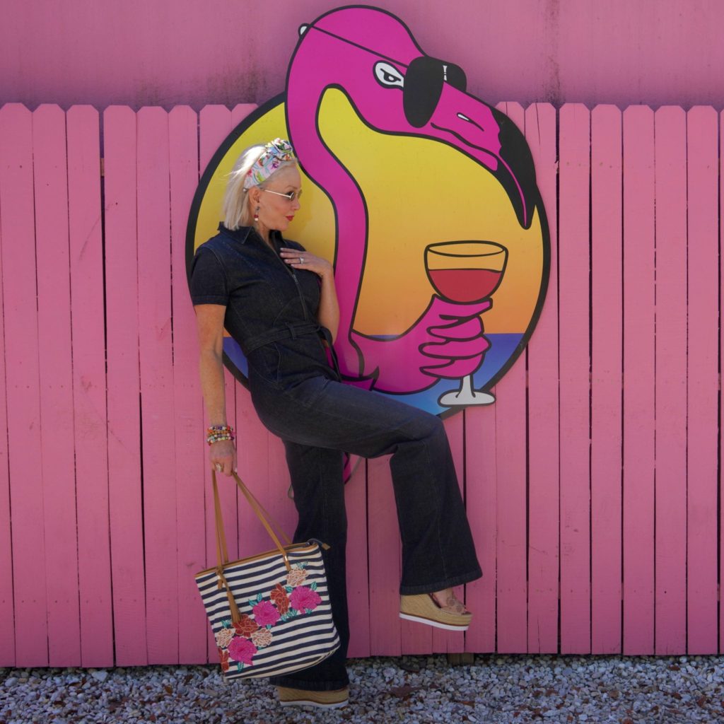 dark blue denim jumpsuit, stipe & floral tote bag, pink wall, Flamingo wall