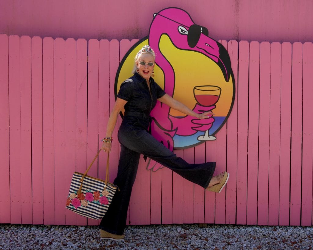 dark blue denim jumpsuit, stipe & floral tote bag, pink wall, Flamingo wall