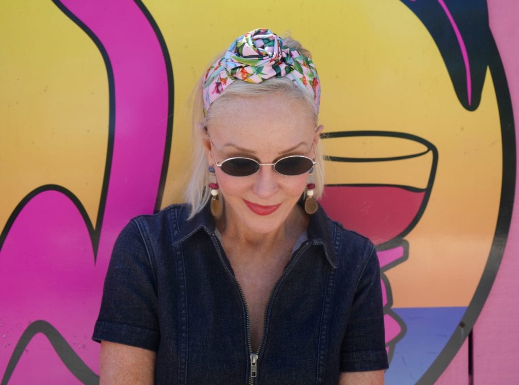 Sheree Frede of the SheShe Show wearing a floral headband and oval wire rimmed sunglasses