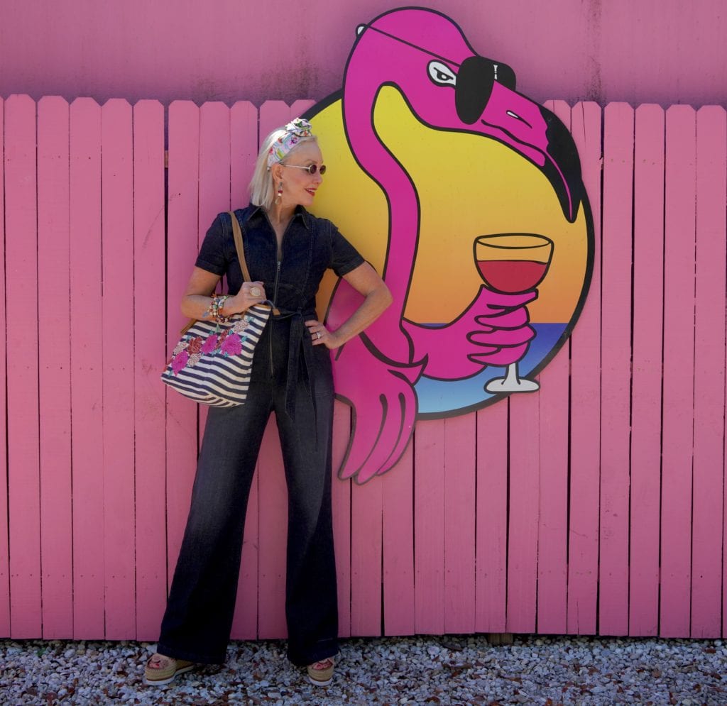 Sheree of the SheShe Show wearing blue denim jumpsuit with floral tote bag