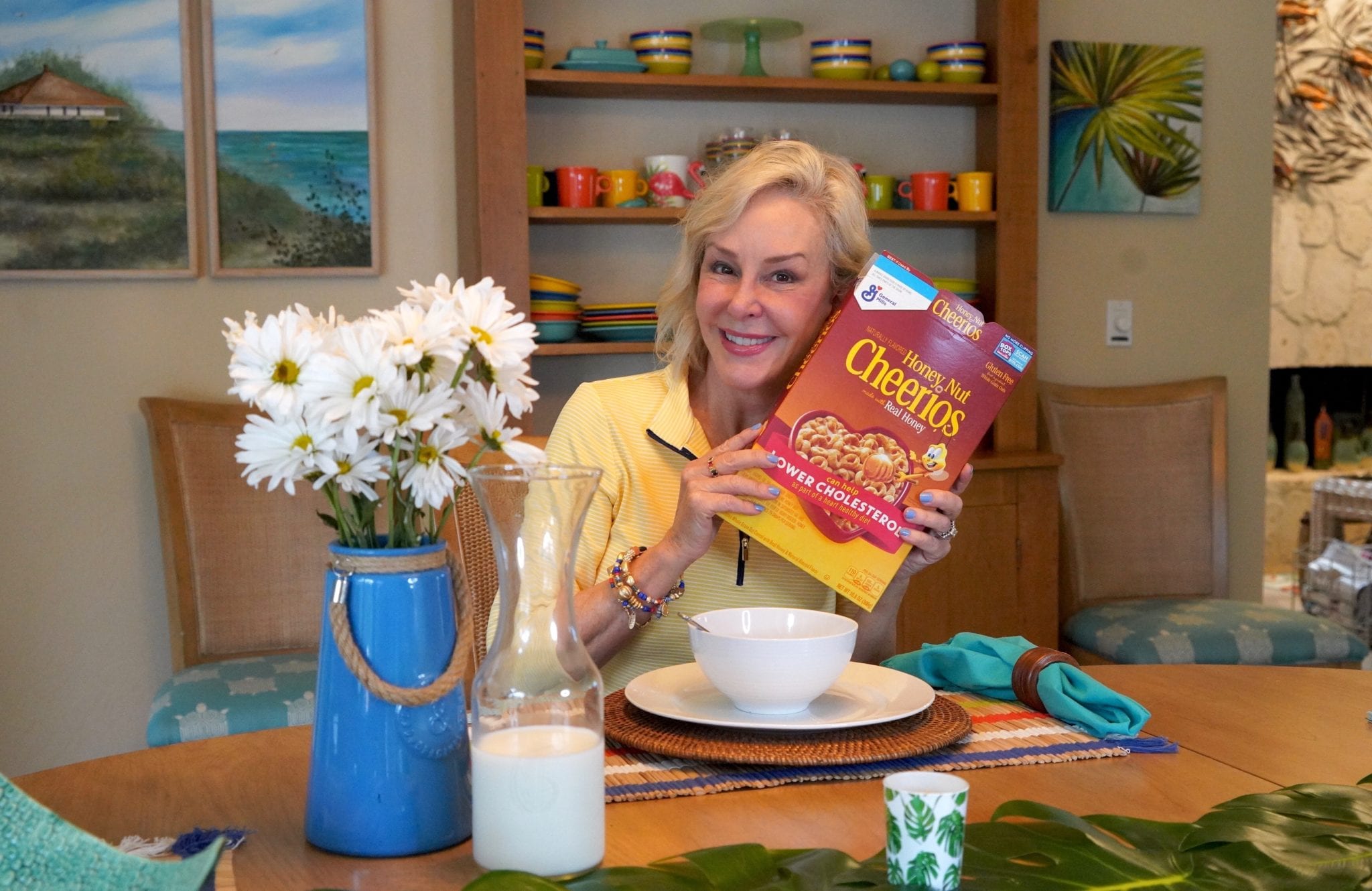 SheSheShow at breakfast table pointing at Cheerio's box