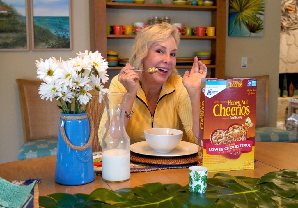 SheSheShow at breakfast table pointing at Cheerio's box
