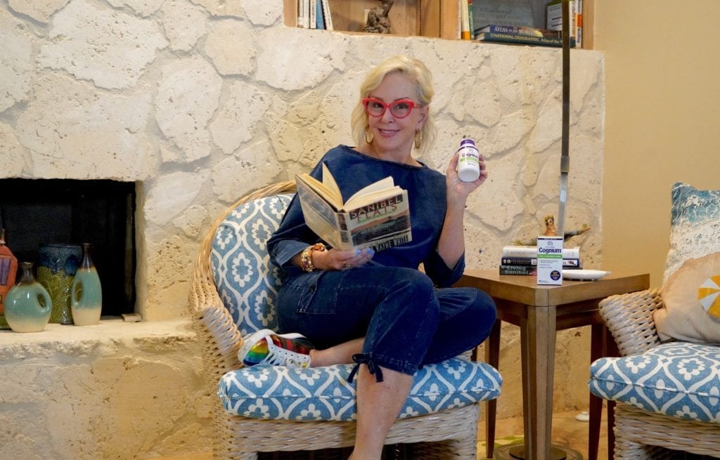 Sheree of the SheShe Show reading a book sitting in chair