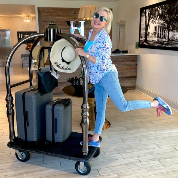 Sheree of the SheShe Show on luggage cart with suitcases