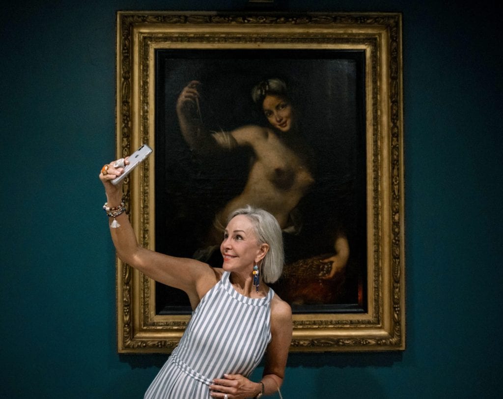 Sheree of SheShe Show posing in front of antique portrait