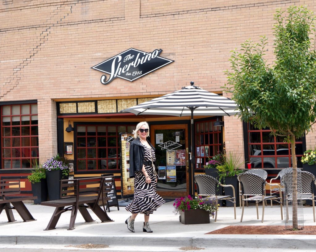 SheShe of the SheShe Show wearing zebra print maxi dress with leather bomber jacket in old western downtown 