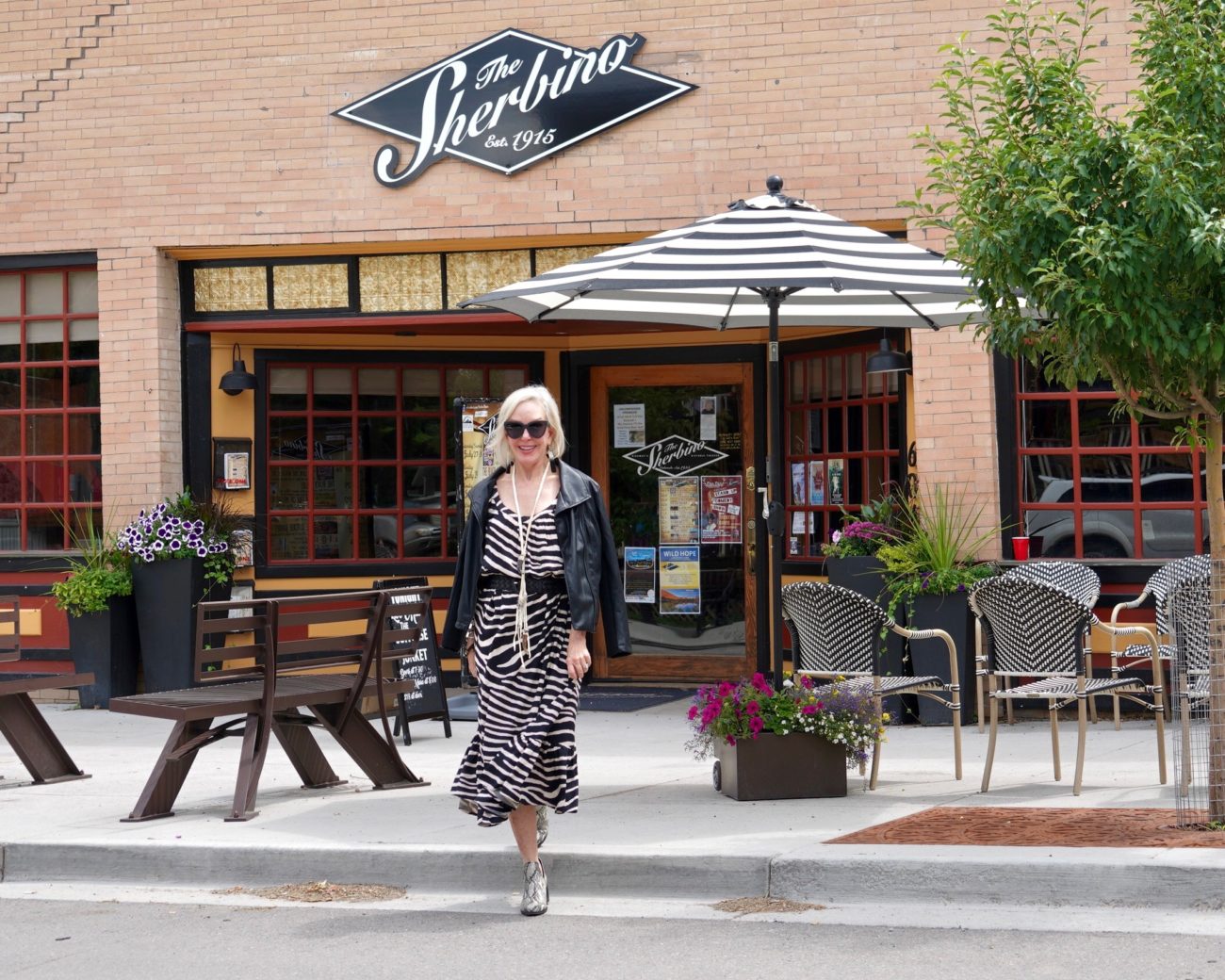 SheShe of the SheShe Show wearing zebra print maxi dress with leather bomber jacket in old western downtown