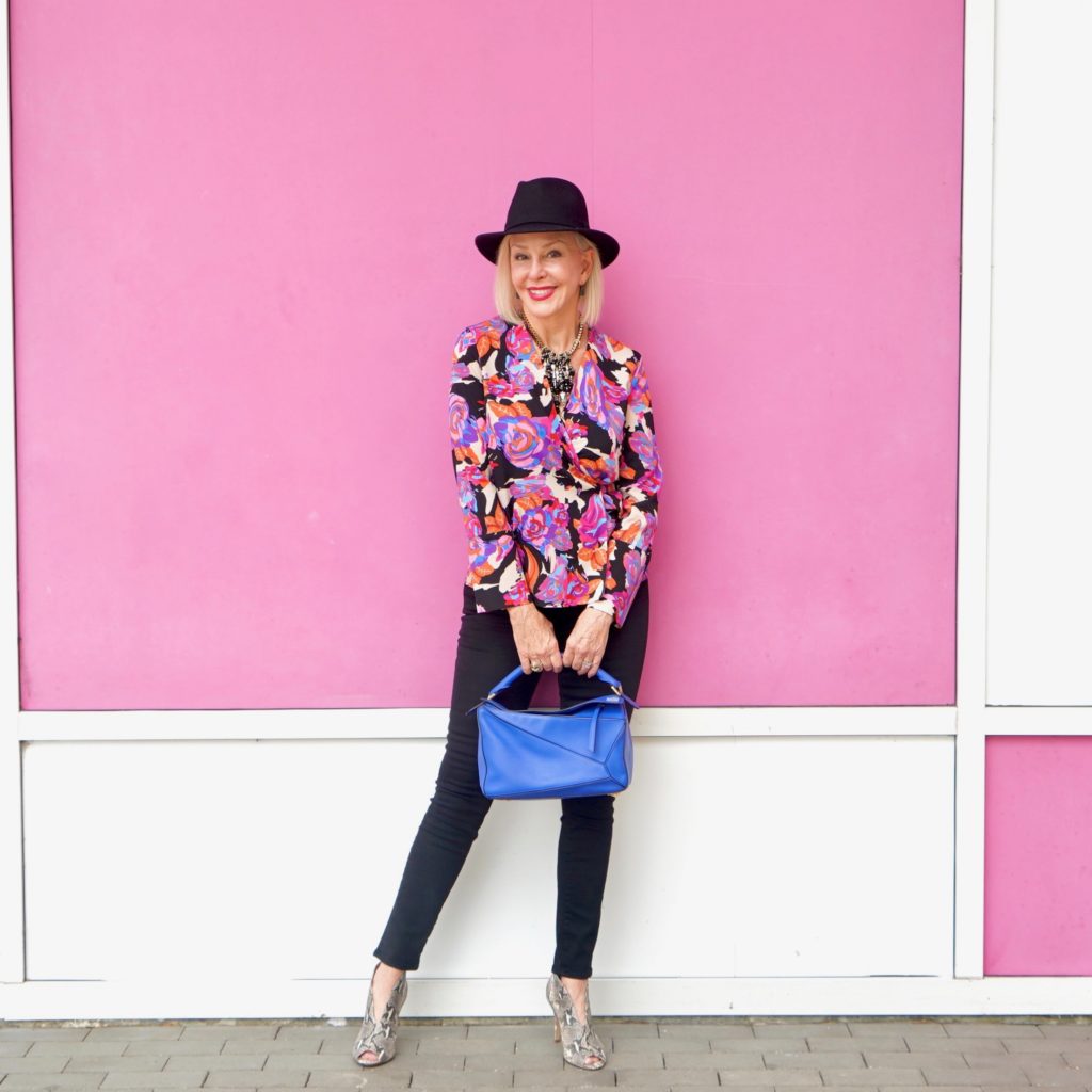 Sheree Frede of the SheShe Show wearing bright colored top, black jeans wearing black fedora hat