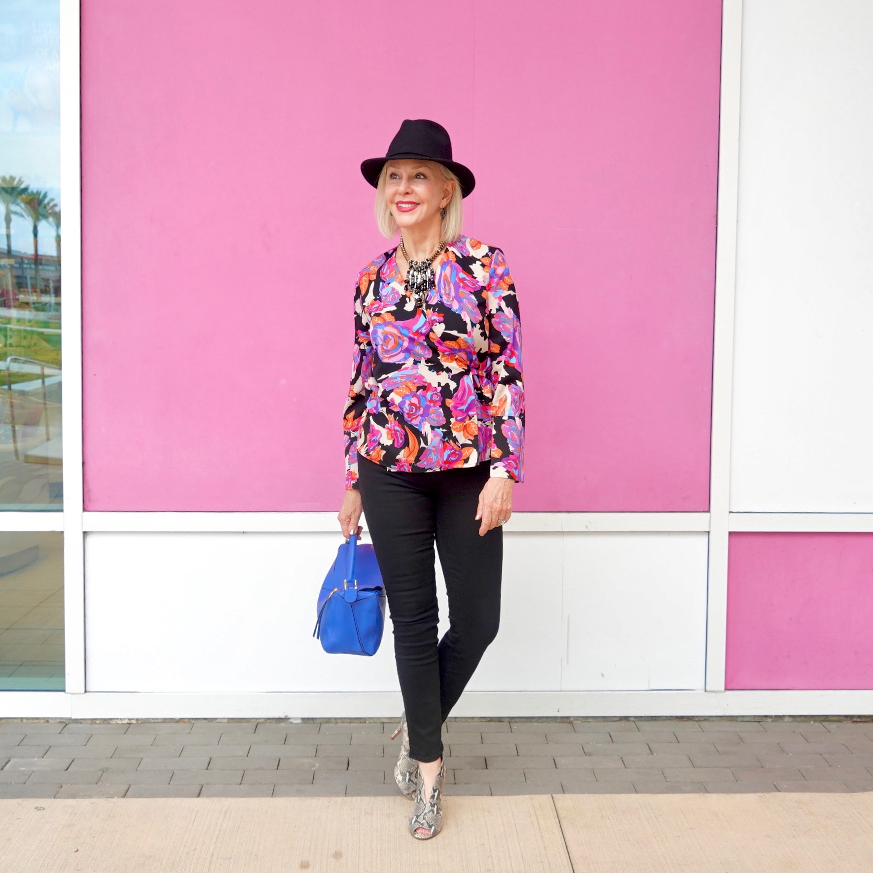 Sheree Frede of the SheShe Show wearing bright colored top, black jeans wearing black fedora hat