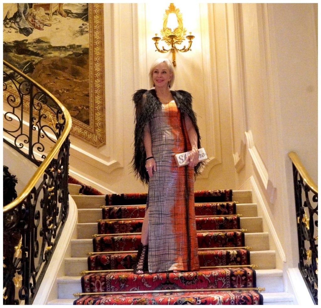 Sheree Frede of the SheShe Show standing on the grand staircase at the Ritz in Paris wearing a ball gown.