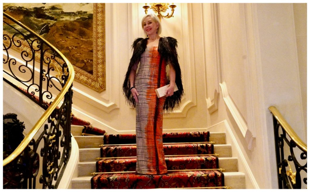 Sheree Frede of the SheShe Show standing on the grand staircase at the Ritz in Paris wearing a ball gown.