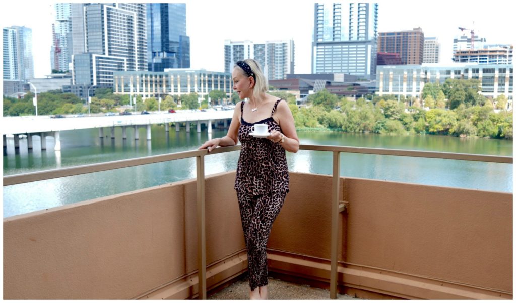 SheShe of the SheShe Show wearing leopard pj's on lake balcony in Austin