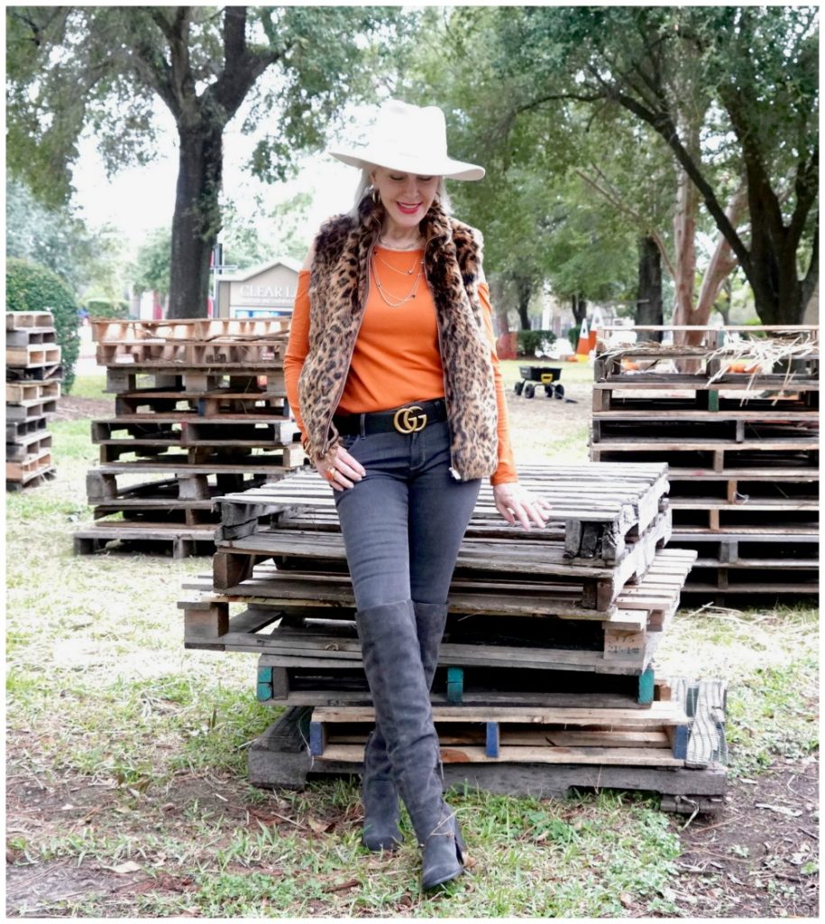 Sheree Frede of the SheSheShow wearing a leopard faux fur vest, jeans, boots, orange top and white hat
