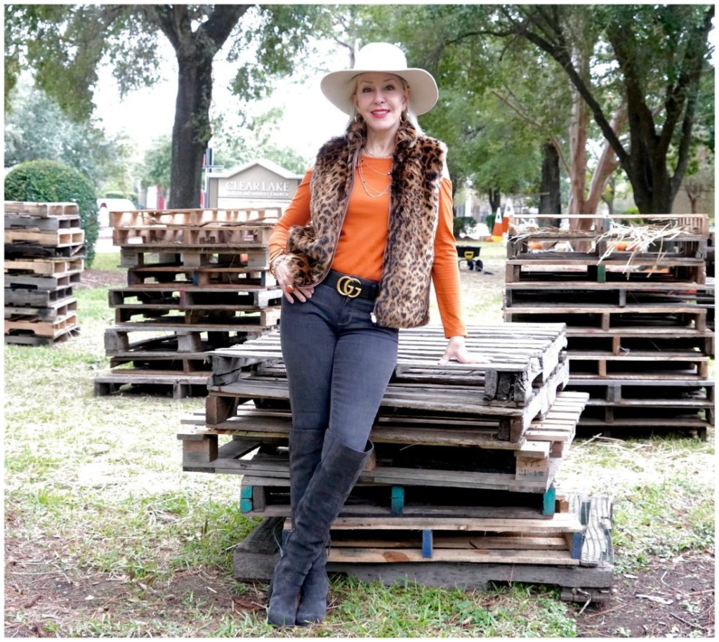 Sheree Frede of the SheSheShow wearing a leopard faux fur vest, jeans, boots, orange top and white hat