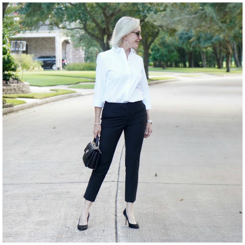 Sheree of the SheShe Show wearing basic black pants and white shirt with black pumps and Chanel bag