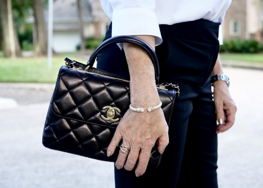 Up close photo of black Chanel handbag and David Yurman accessories.