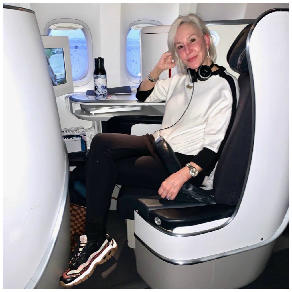 Sheree sitting in chair on plane to Paris wearing all chicos outfit and skechers sneakers