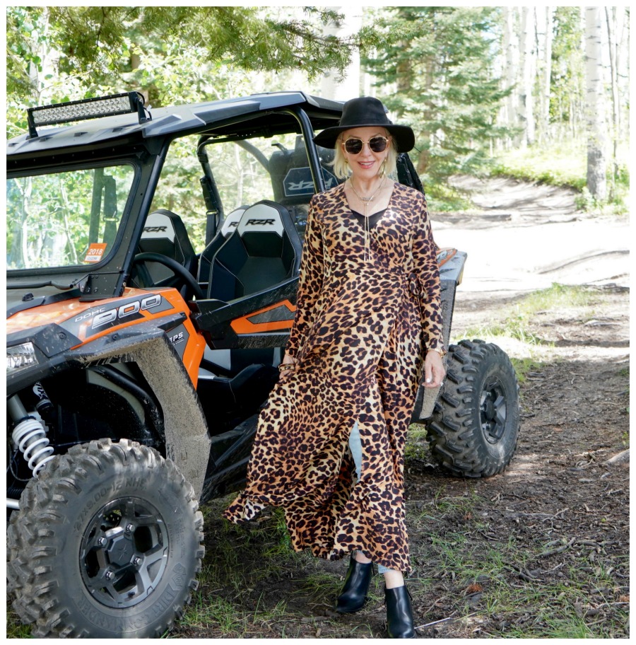 SheShe of the SheShe Show wearing a leopard wrap dress over hight blue jeans and black hat