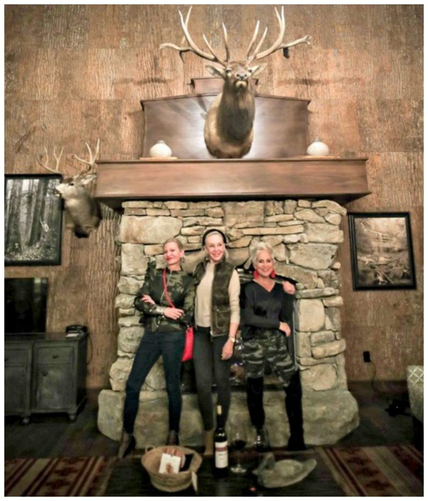 Jamie, SheShe & Shauna standing infront of stone fireplace at Cypress Lodge