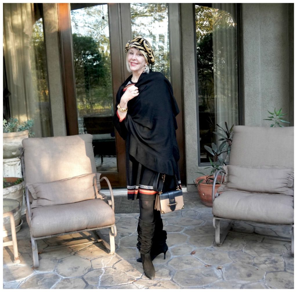 Sheree of the SheShe Show wearing a black wrap over a sweater dress and hat