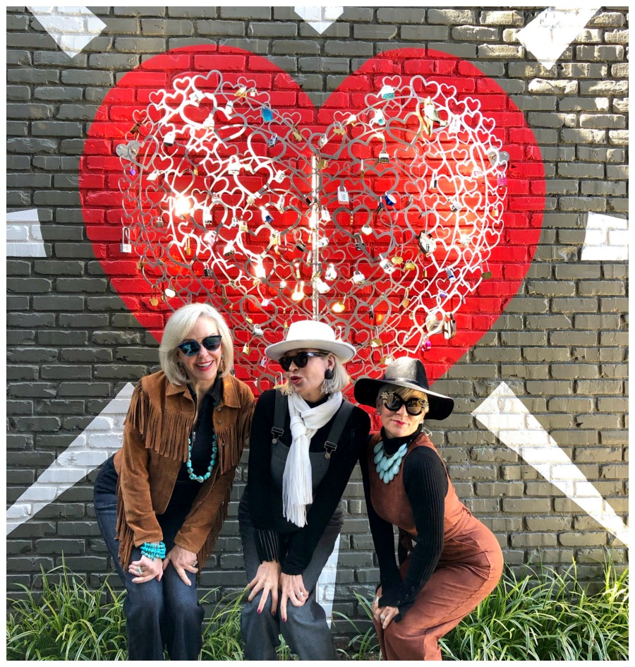 SheShe, Jamie, and Shauna posing in front of a heart wall mural