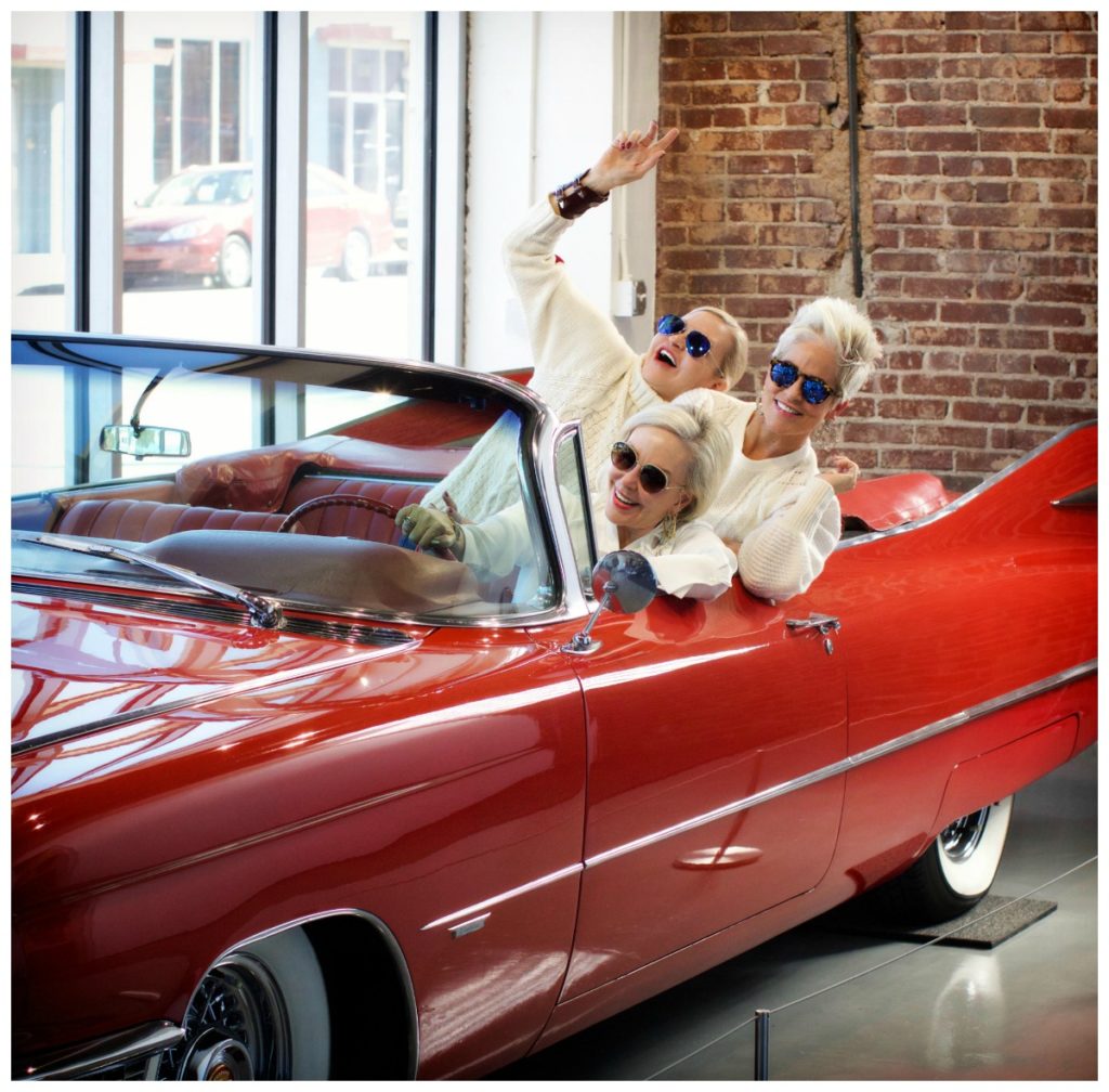 SheShe driving a vintage red convertible car at Edge car museum in Memphis, TN