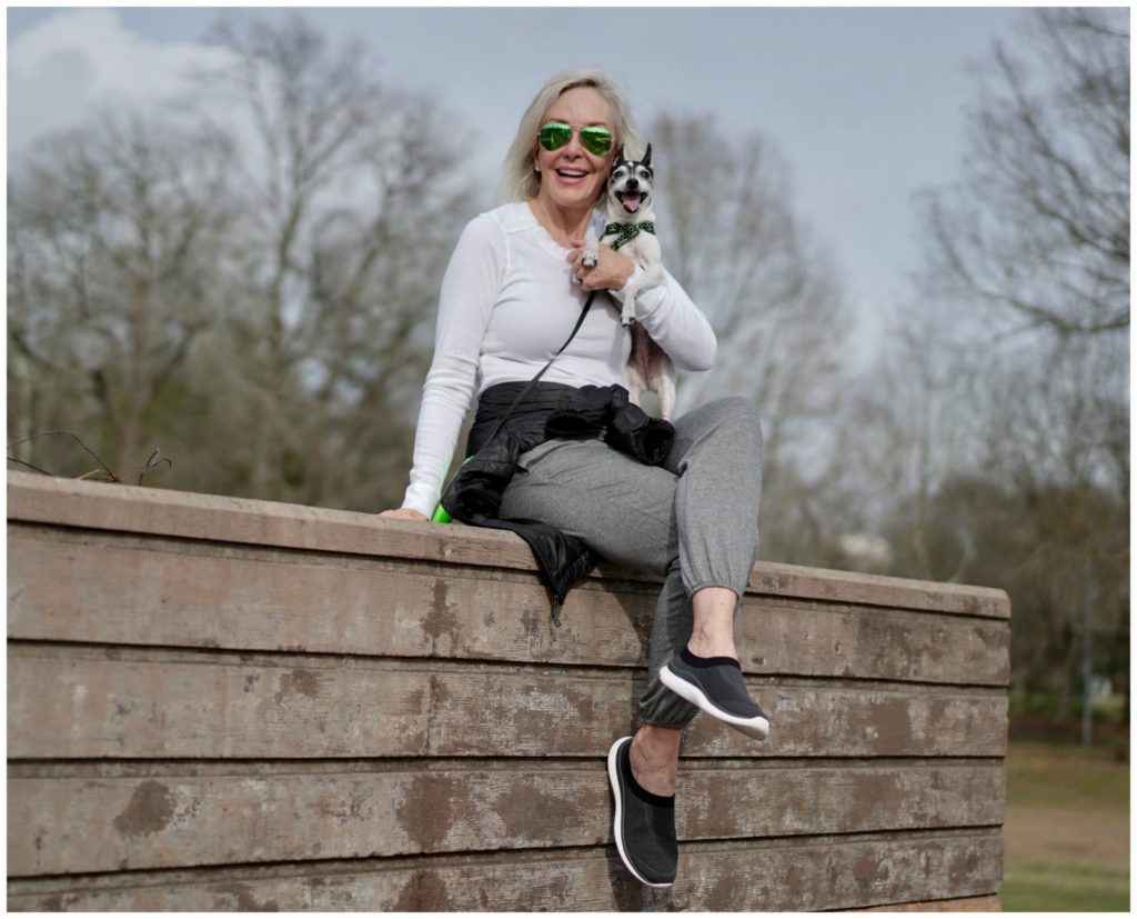sheree Frede of the SheShe Show walking dog across a bridge wearing athleisure