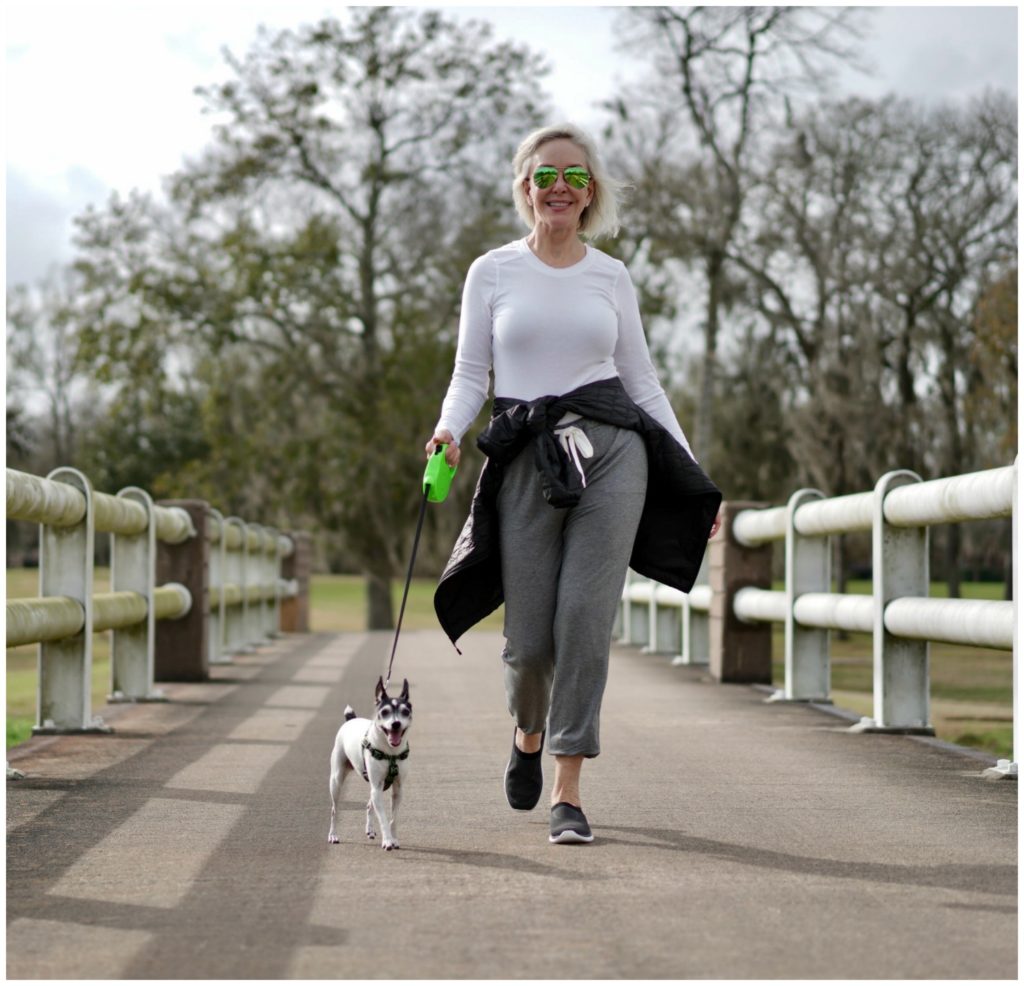 sheree Frede of the SheShe Show walking dog across a bridge wearing athleisure