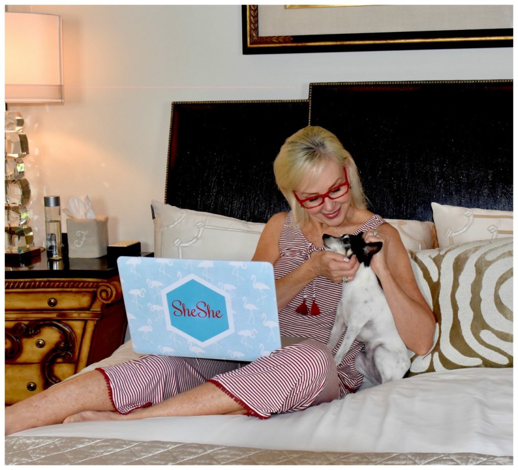 Sheree Frede of the SheShe Show on bed with her Toy Fox Terrier dog Pippa