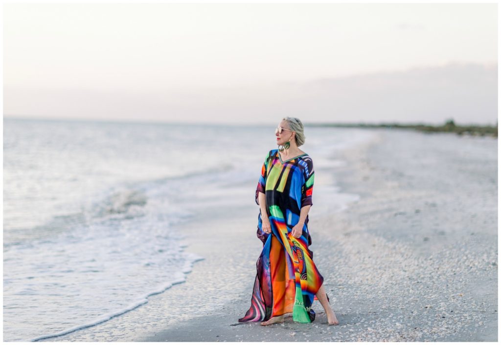 Sheree of the SheShe Show on the beach wearing an abstract multi colored kaftan