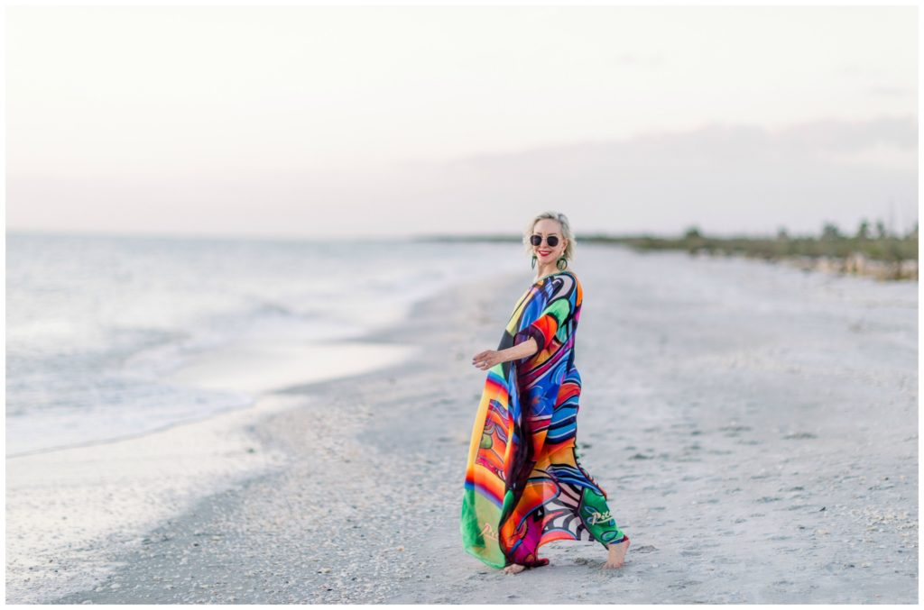 Sheree of the SheShe Show on the beach wearing an abstract multi colored kaftan