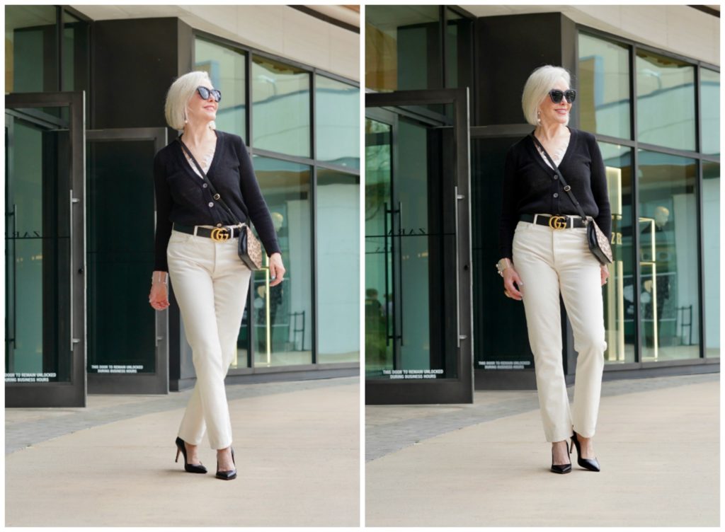 Sheree Frede of the SheShe Show standing in front of a store front wearing off white jeans and black sweater.