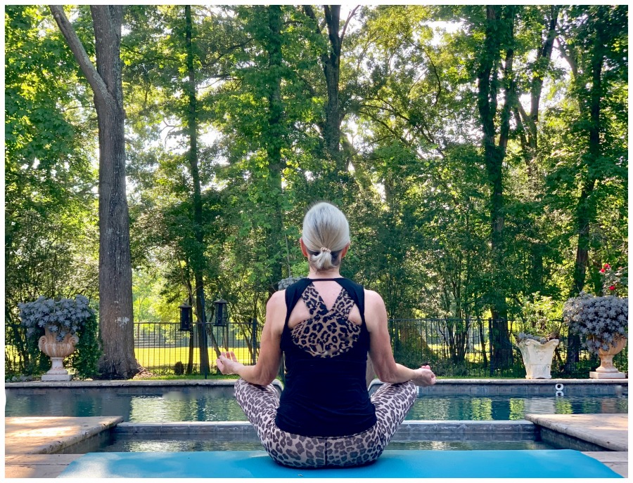 Sheree of the SheSheShow meditating by the swimming pool 