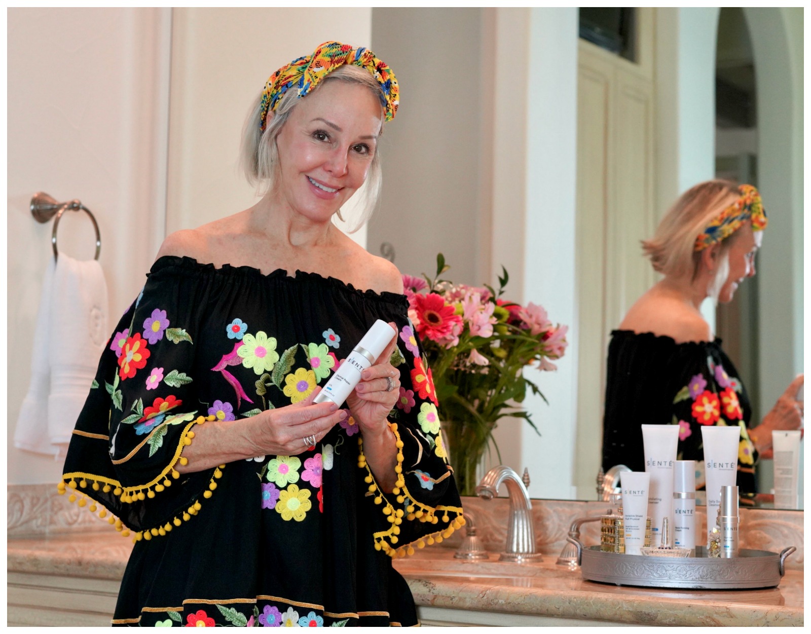 Sheree Frede founder of the SheSheShow applying Sente skincare in her bathroom wearing a black floral offtheshoulder top