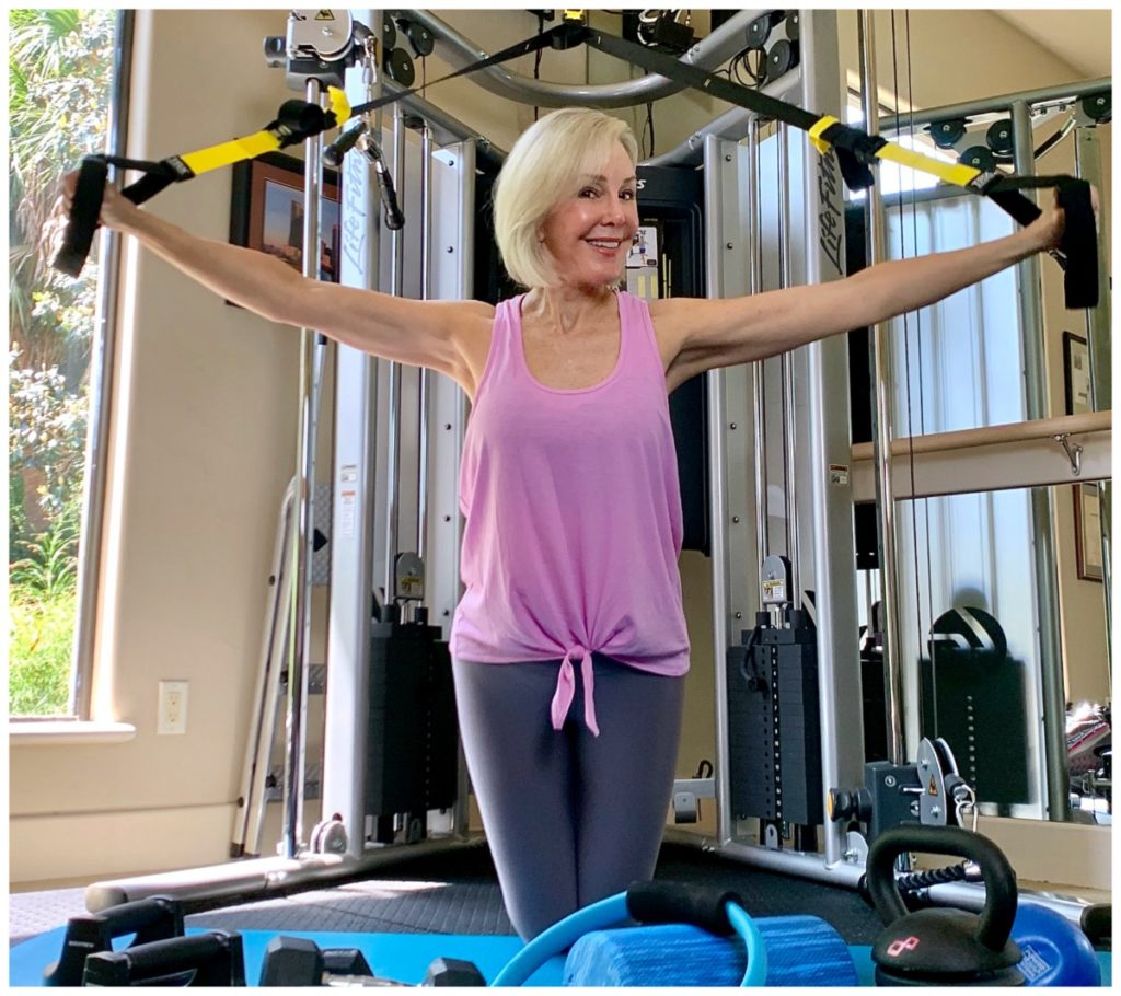 Sheree Frede of the SheShe Show in home gym wearing a pink tank over gray leggings