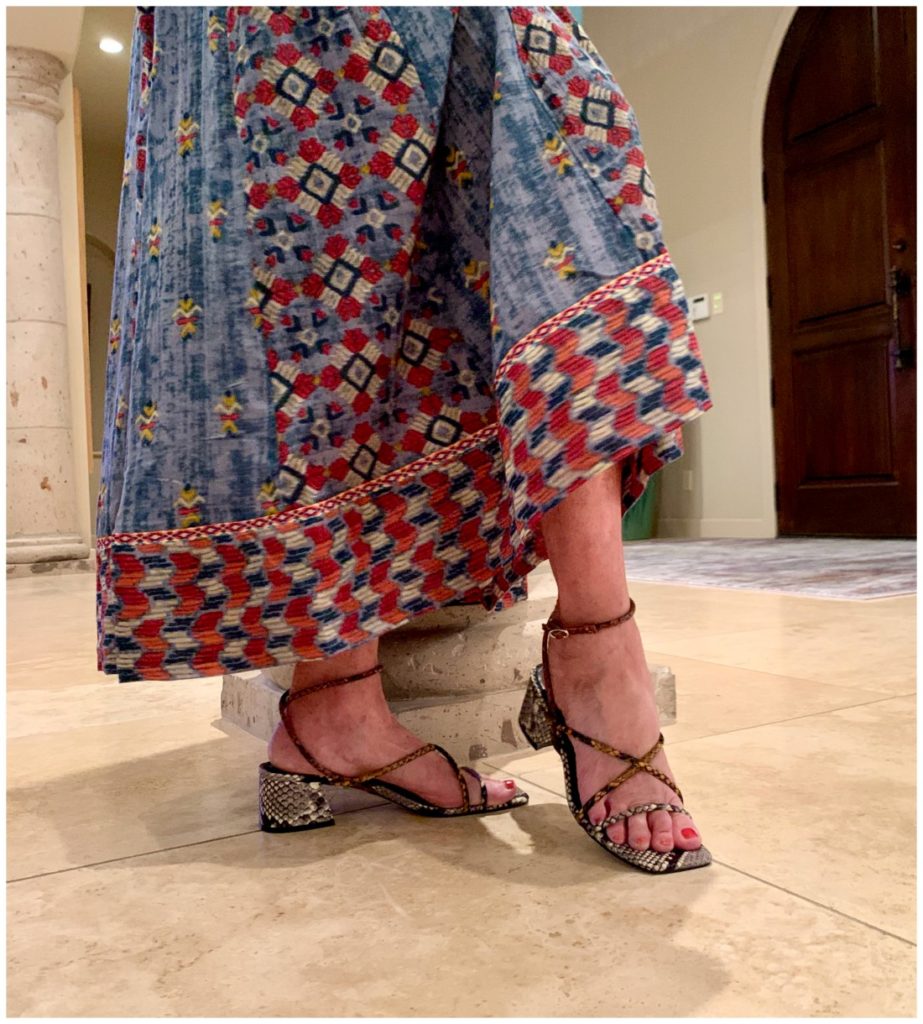 Sheree Frede of the SheShe Show standing in foyer by column wearing a chambray maxi dress accented in embellishments