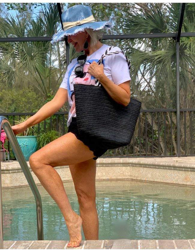Sheree Frede stepping into swimming pool wearing shorts and hat