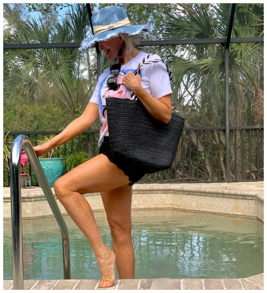 Sheree Frede stepping into swimming pool wearing shorts and hat