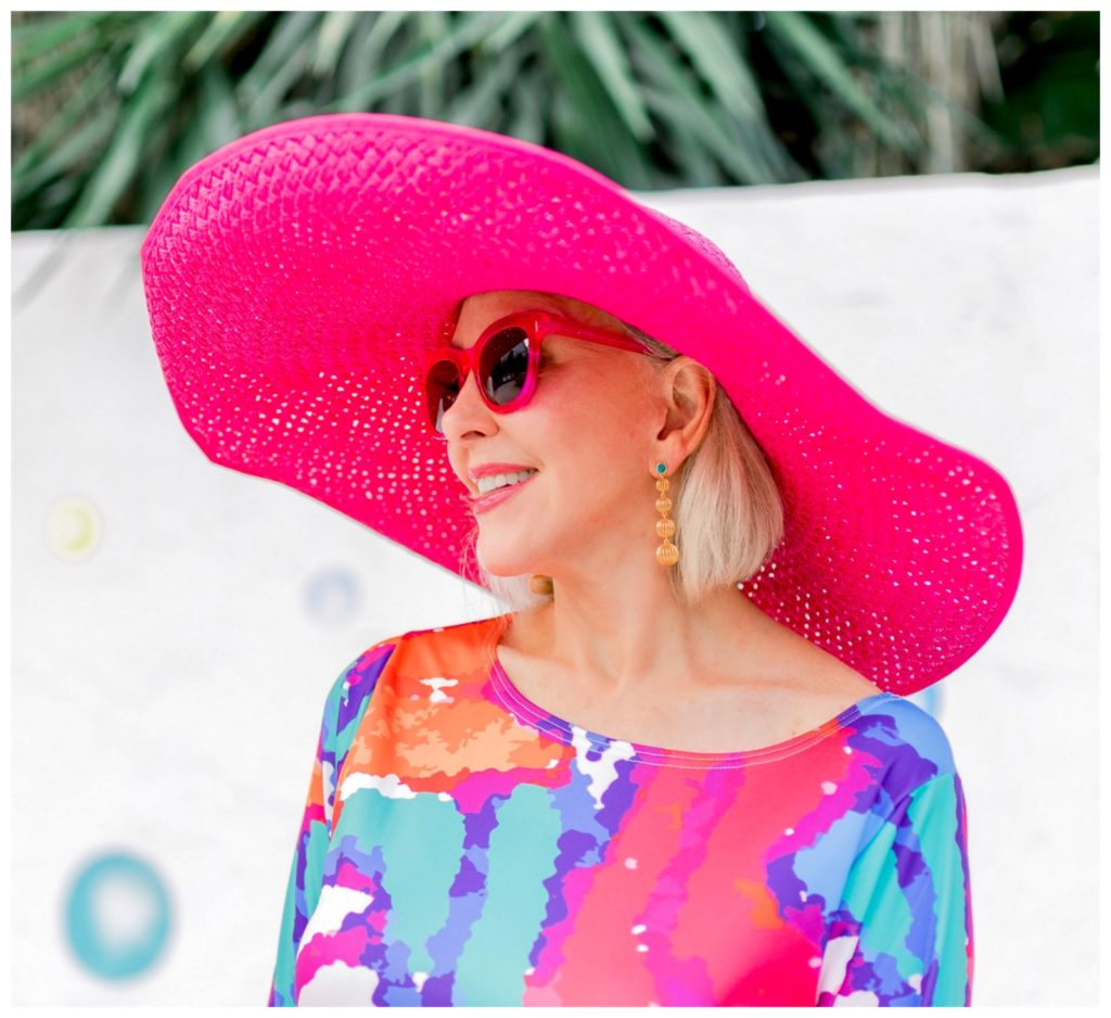 Sheree Frede of the SheShe Show wearing a big pink hat and colorful print dress