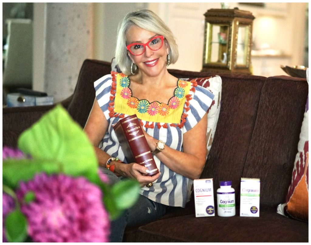 Sheree Frede of the SheShe Show sitting on sofa looking at photos with Natrol Memory supplements
