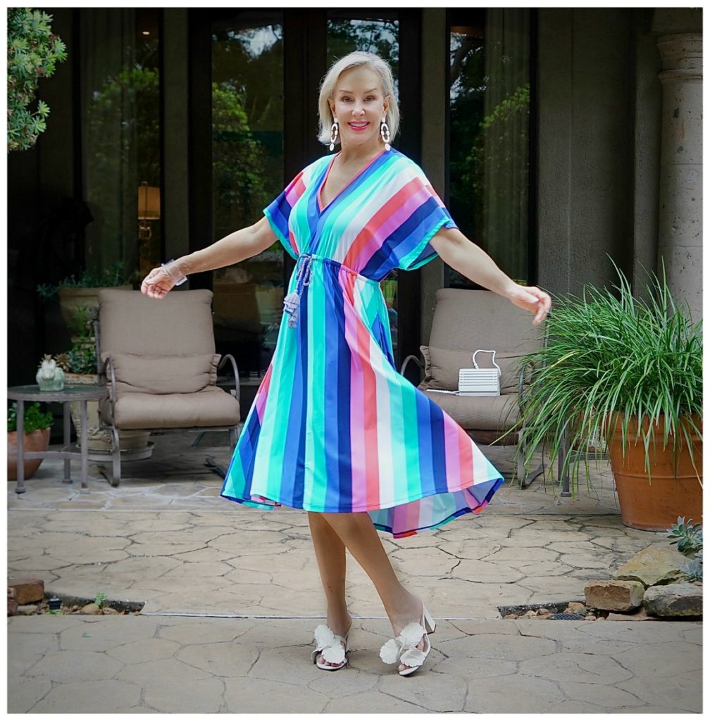 Sheree Frede of the SheShe Show twirling in a colorful stripe midi dress for swim cover-ups
