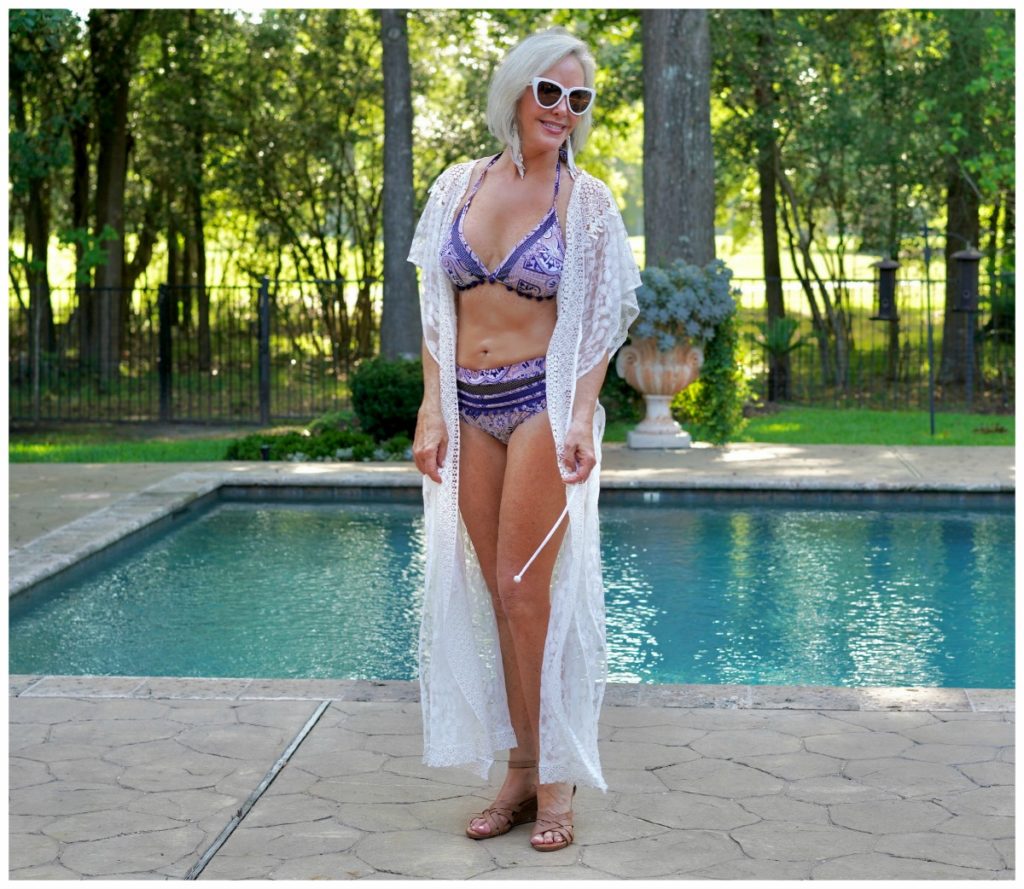 Sheree Frede of the SheSheSHow by swimming pool wearing white long lace swimsuit coverup over 2 pc swimsuit