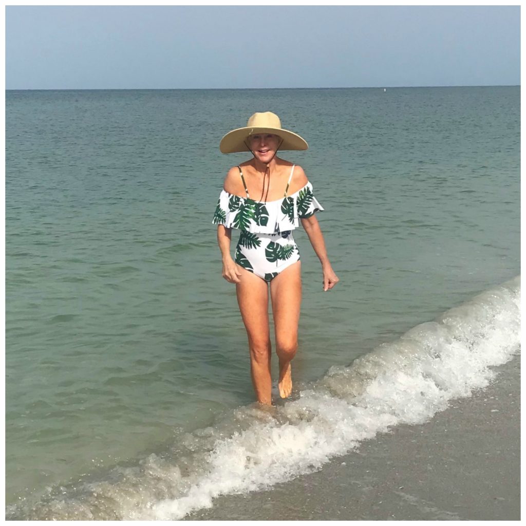 Sheree Frede of the SheSheShow wearing a tropical print off the shoulder swimsuit