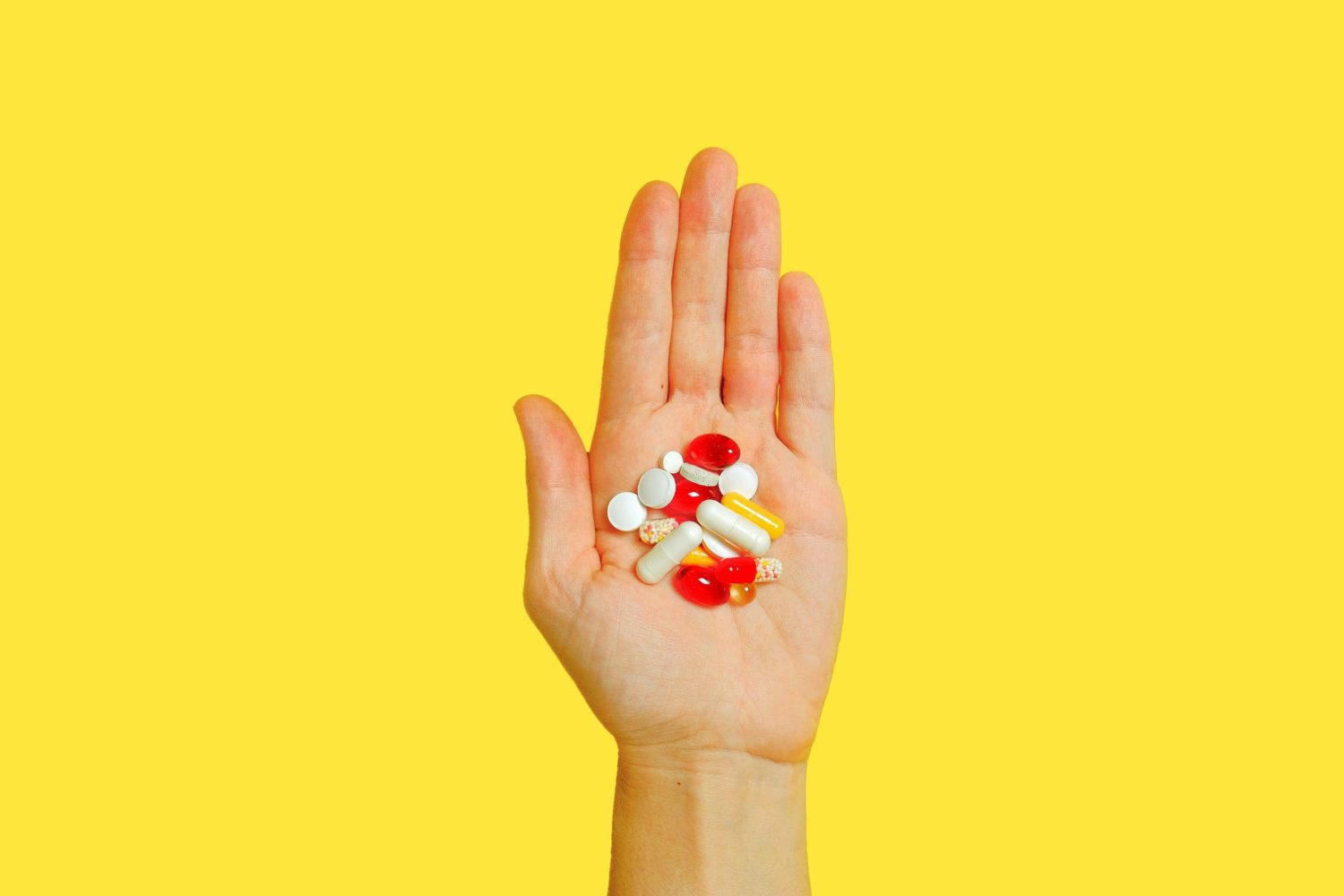 photo of a hand holding several vitamins