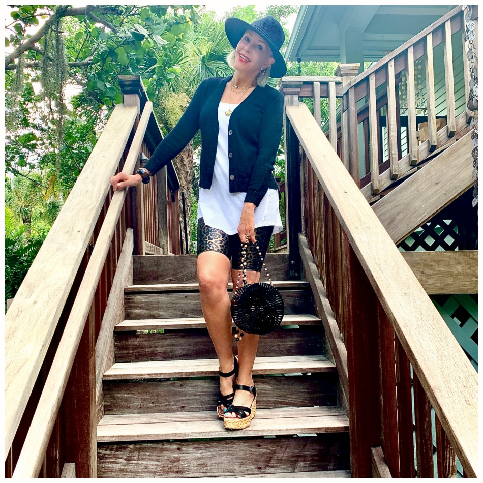 instagram shot of Sheree Frede of the SheShe Show walking up outdoor wooden stairs wearing bike shorts and black cardigan with black hat