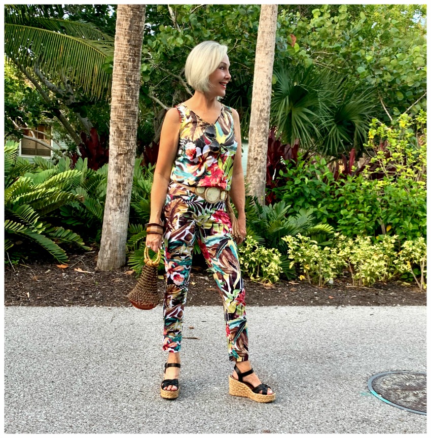 Sheree Frede of the SheShe Show standing in tropical foliage wearing a tropical pants outfit