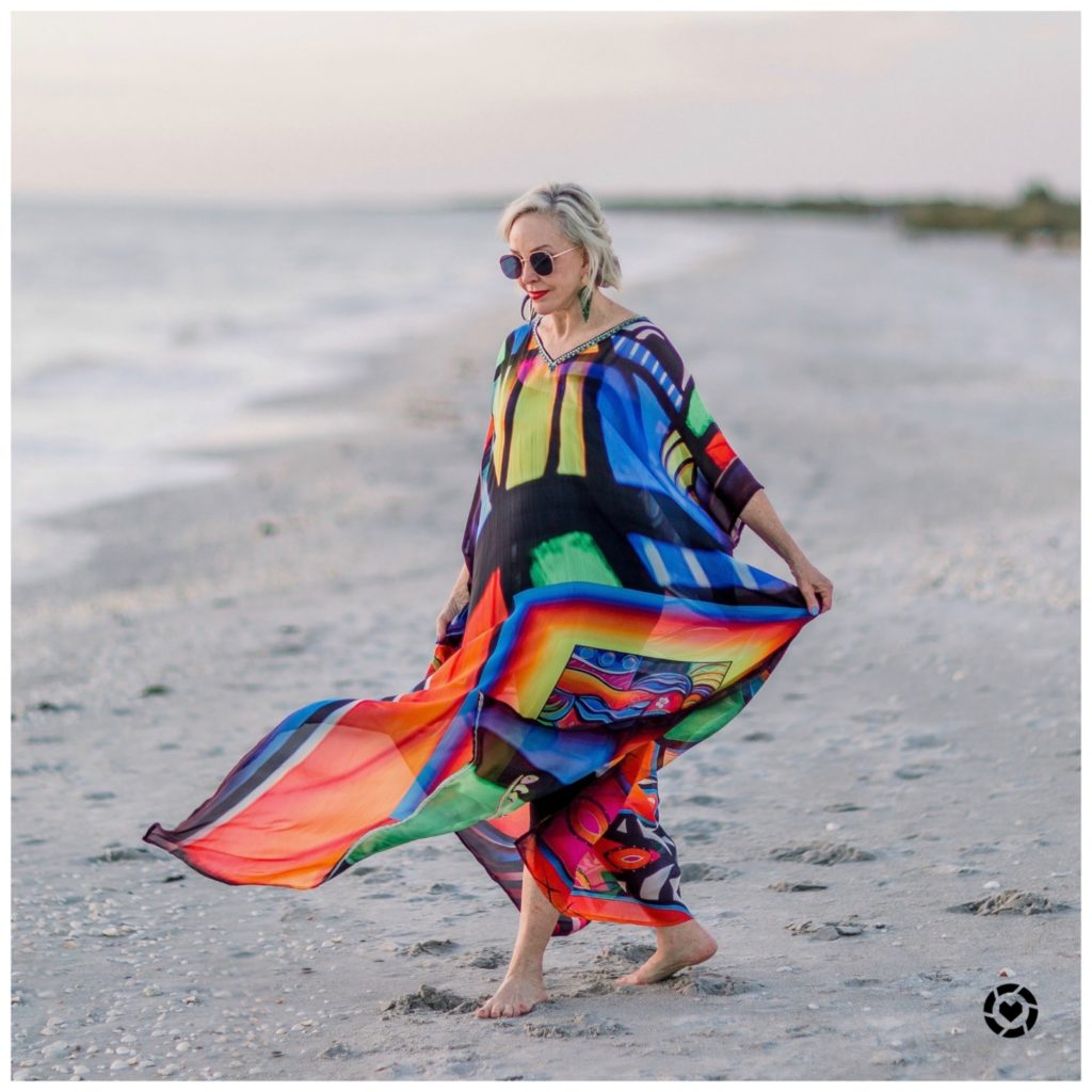 Sheree Frede of the SheShe Show at the. beach wearing a bright multi colored kaftan