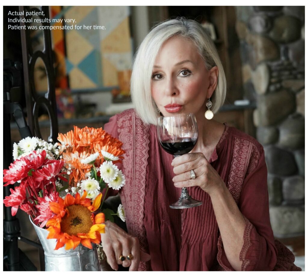 Sheree Frede of the SheSHeShow having a glass of red wine.